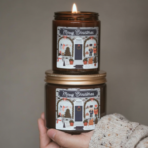 two christmas candles held in the candle of a person wearing a thick wooly jumper
