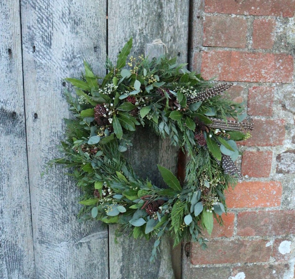 a father Christmas wreath hangs on a barn door
